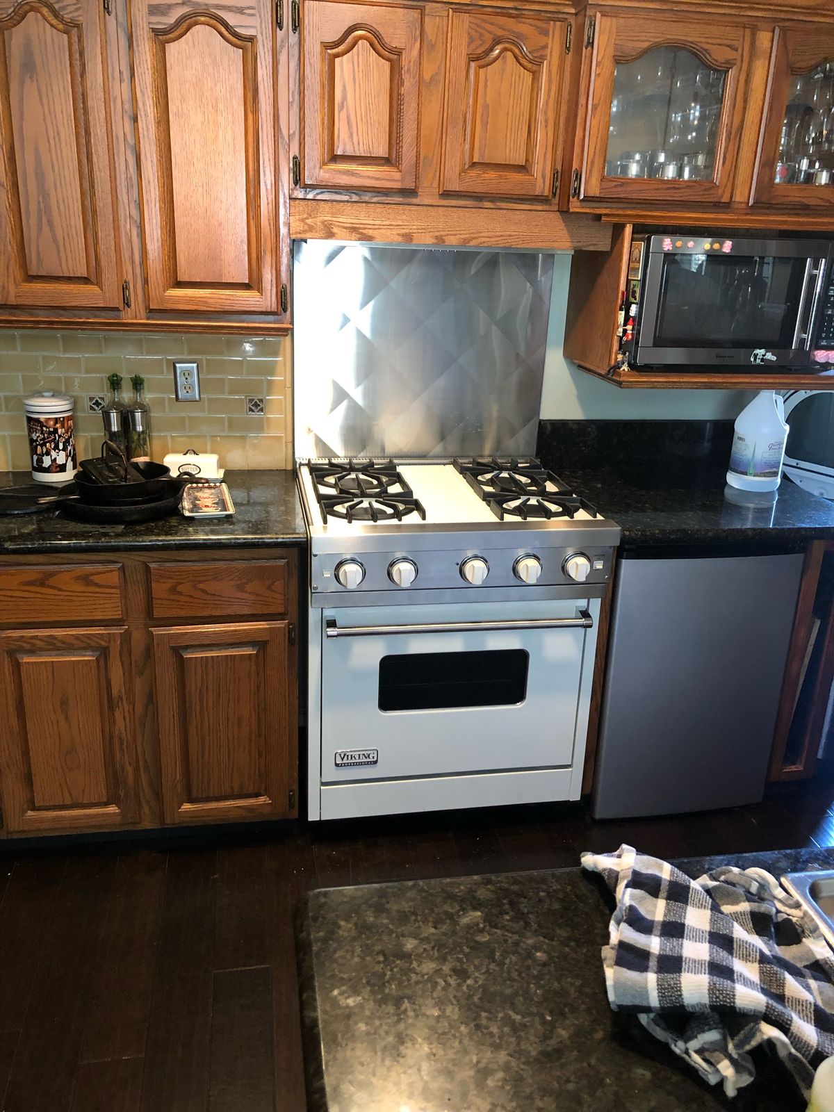 Kitchen before, with oak cabinets and an older tile backsplash